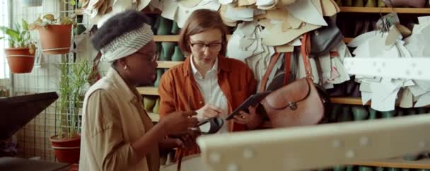 非裔美国人和白人女性制鞋工人在车间检查鞋子和制作数码平板电脑 — 图库视频影像