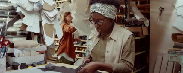 Ung Afroamerikansk Kvinna Skära Läder Medan Arbetar Med Kaukasiska Kollega — Stockvideo