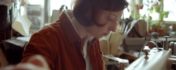 鞋匠车间台面缝纫机女用皮革倾斜下拍 — 图库视频影像