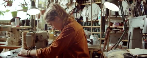 在制鞋工场工作期间 白种人年轻妇女与缝纫机坐在办公桌前拍照的肖像 — 图库视频影像