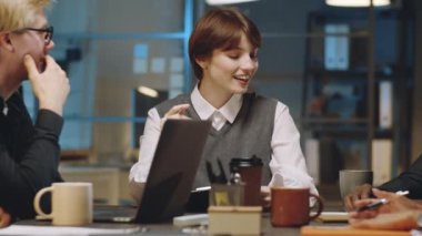 Genç, güzel iş kadını. Ofiste yapılan toplantıda gülümseyen ve etnik çeşitliliğe sahip meslektaşlarıyla konuşan.