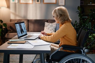 Üst düzey kadın çevrimiçi konuşma için dizüstü bilgisayar kullanıyor