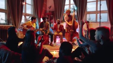 Yavaş çekim, çok ırklı müzik grubunun stüdyoda canlı konser vermesi ve insanların onlara el çırpması.