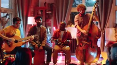 Genç Afro-Amerikalı erkeklerin şarkı söylemelerini, beyaz müzisyenlerin gitar çalmasını ve canlı konser verirken bas gitar çalmalarını çek.