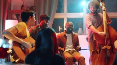 Genç Afrikalı Amerikalı bir adam konser sırasında canlı müzik çalarken şarkı söylüyor.