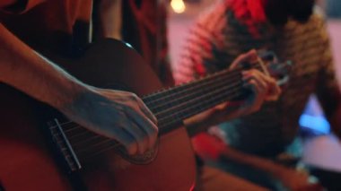 Ortadoğulu genç müzisyenin müzik grubuyla konser verirken gitar çalışını yakından çek.