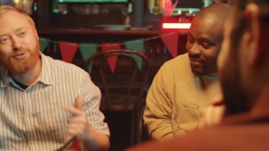 Etnik çeşitliliğe sahip bir grup erkek birlikte harika bir akşam geçiriyorlar. Gastrobar 'da canlı sohbetler yapıyorlar.