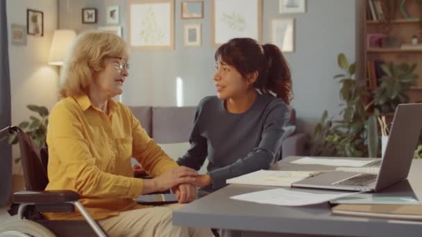 Medium Shot Young Volunteer Sitting Front Elderly Woman Wheelchair Holding — Stock Video