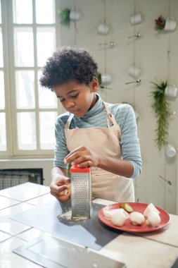 Çocuk masada yemek pişiriyor.