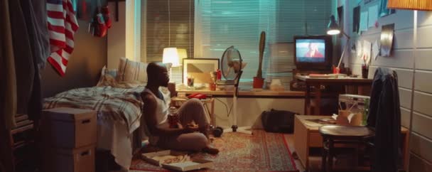 Afro Américain Assis Sur Sol Soir Maison Regarder Télévision Manger — Video
