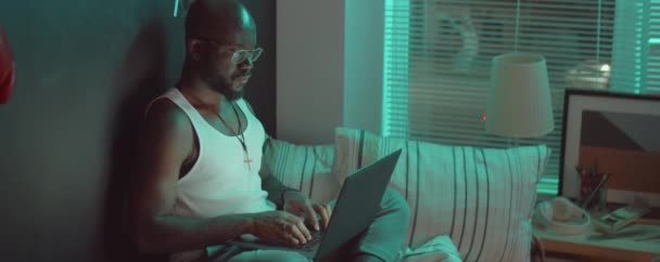 Afro Américain Lunettes Débardeur Tapant Sur Ordinateur Portable Tout Étant — Video