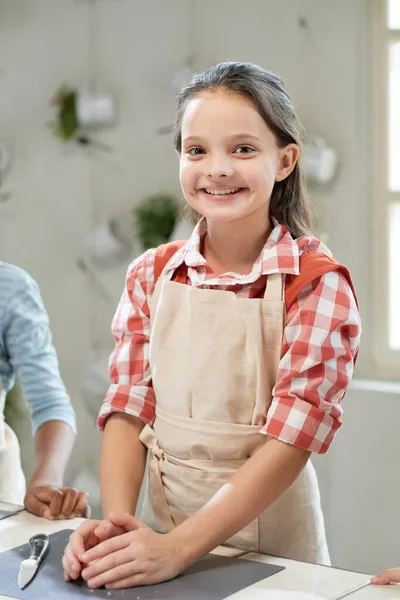 Щаслива маленька дівчинка готує за столом — стокове фото