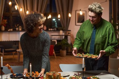 Evde akşam yemeği düzenleyen çift.