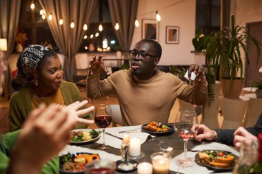 Adam masada arkadaşlarıyla oyun oynuyor.
