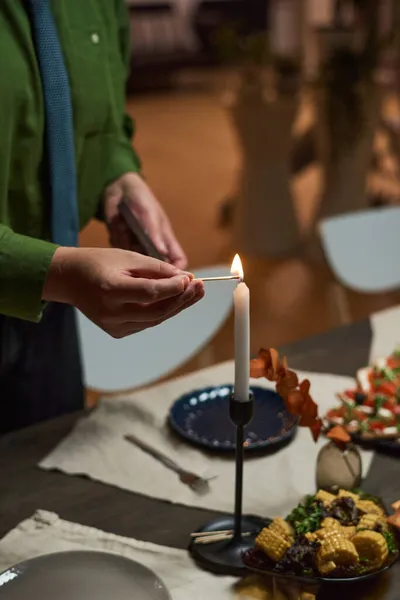 Человек зажигает свечу на обеденном столе — стоковое фото