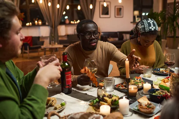 Arkadaşlar yemek yiyor ve şarap içiyor.
