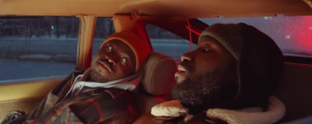 两个年轻黑人坐在车窗里 晚上聊天 从车窗往外看 — 图库视频影像
