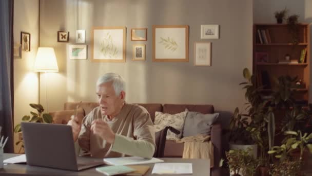 Portrét Staršího Muže Neformálním Oblečení Brýlích Sedícího Stolem Obývacím Pokoji — Stock video