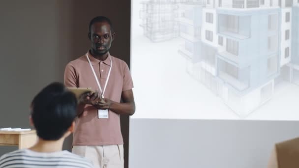Zwarte Mannelijke Architect Staat Met Digitale Tablet Door Whiteboard Geeft — Stockvideo