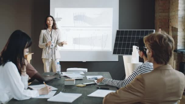 在办公室会议期间 妇女站在白板旁边 向商业团队介绍可再生能源项目 — 图库视频影像