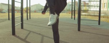 Sporcunun antrenman sahasında durup antrenmandan önce diz çöküp göğüs egzersizi yapmasını çek.