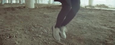 Spor giyim kuşağındaki sporcunun şehir köprüsünün altından atlama halatını şehirde egzersiz yaparken yukarı kaldır.