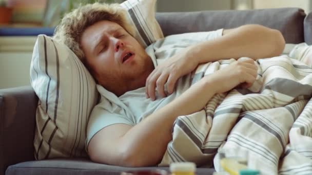 Tilt Shot Sick Man Lying Blanket Sofa Toughing While Staying — Video