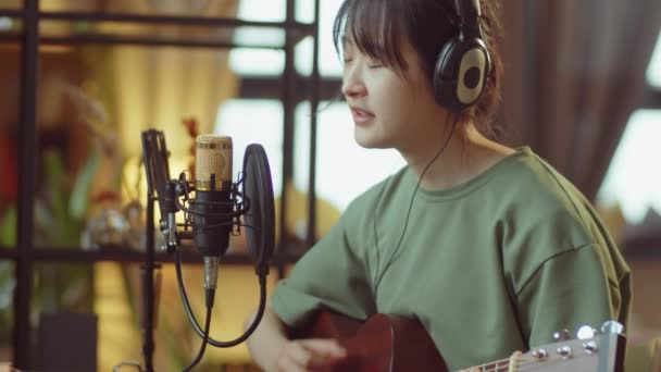 Young Asian Woman Headphones Playing Guitar Singing Microphone Home Recording — Stock Video