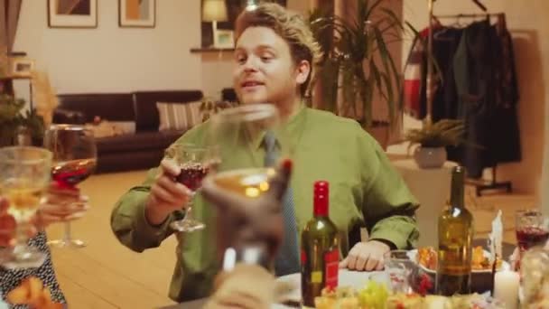 Ünnepi Ebédlőasztalnál Ülő Fiatalember Legjobb Barátaival Pirítóst Poharakat Készít Italokkal — Stock videók