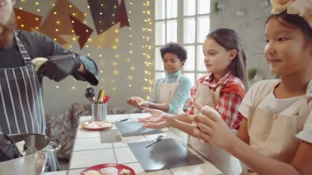 Chef Schürze Und Handschuhen Gibt Fröhlichen Kindern Teigstücke Zum Kneten — Stockvideo
