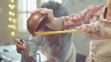 Küçük çocukların yemek pişirirken tavada bal ile armut karamelize ederken yakın plan çekimleri.