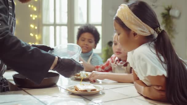 Kokken Tilføjer Sød Topping Til Vafler Til Små Multietniske Børn – Stock-video