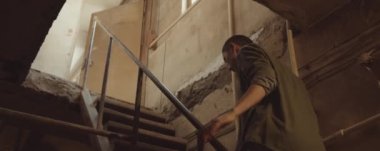 Kadının üst kata çıkıp bodrum katındaki atölyeden çıkarken düşük açılı görüntüsü.