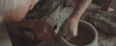 Profesyonel çömlekçi çarkının el yapımı seramik demlik yaparken atölyeye fırlattığı yüksek açılı bir çekim.