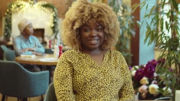 Portret Młodej Afroamerykanki Siedzącej Przy Stoliku Patrzącej Kamerę Uśmiechającej Się — Wideo stockowe