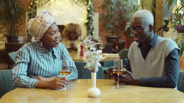 Молодые Афроамериканец Женщина Сидят Вместе Столом Кафе Пьют Вино Смотрят — стоковое видео