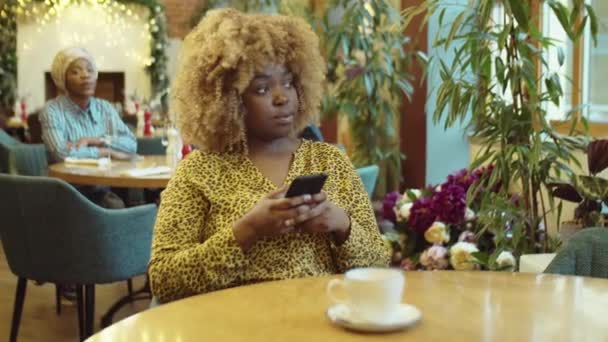 Young African American Woman Sitting Cafe Table Using Mobile Phone — Stock Video