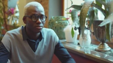 Kafede iş arkadaşıyla konuşan Afrikalı bir Amerikalının omzunun üstünden.