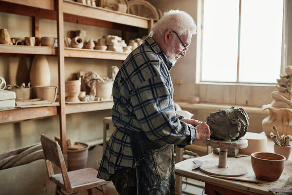 Man shaping clay sculpture in the studio