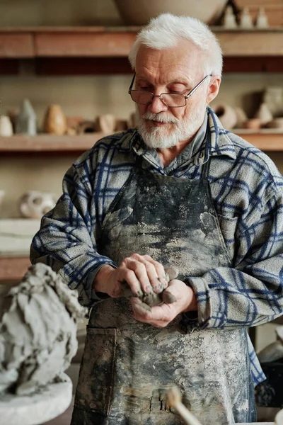 Человек делает фигурки из глины — стоковое фото