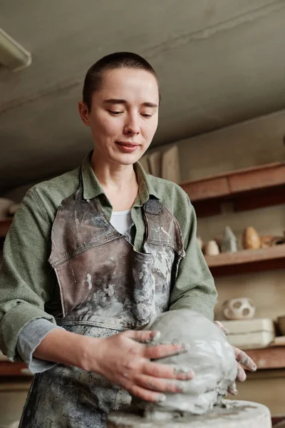 Женщина создает глиняную скульптуру в мастерской — стоковое фото