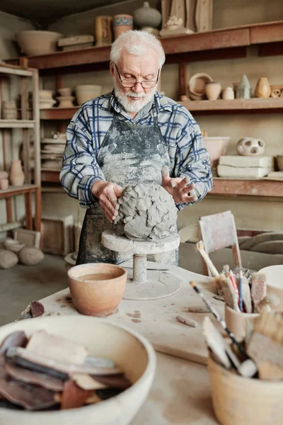 Man making vase from clay in studio — 图库照片