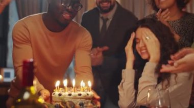 Kafkasyalı genç bir kadın akşamları en iyi arkadaşlarıyla doğum gününü kutluyor dilek diliyor ve doğum günü pastası mumlarını üflüyor.