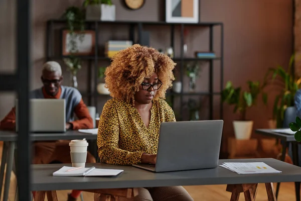 iş kadını ofiste dizüstü bilgisayarda yazarak