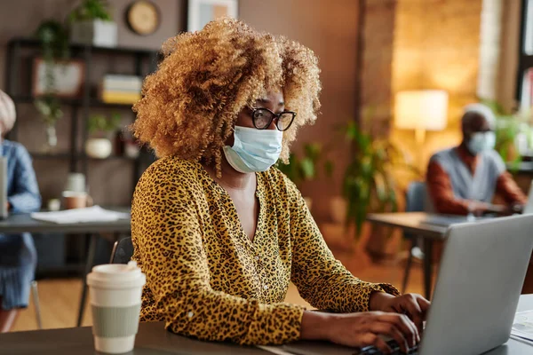 Femme d'affaires en masque travaillant au bureau — Photo