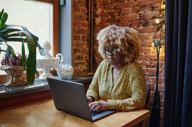 Kafede bilgisayarla çalışan bir kadın