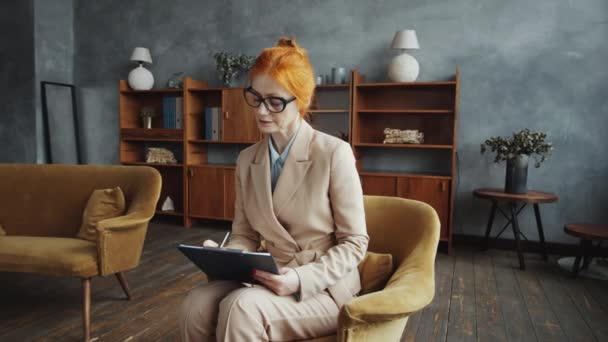 Erfahrene Rothaarige Beraterin Brille Und Elegantem Outfit Sitzt Sessel Macht — Stockvideo