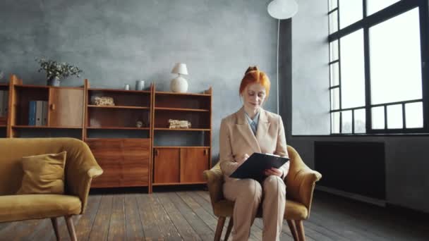 Zoom Toma Hermosa Pelirroja Consejera Sentada Sillón Escribiendo Portapapeles Luego — Vídeos de Stock