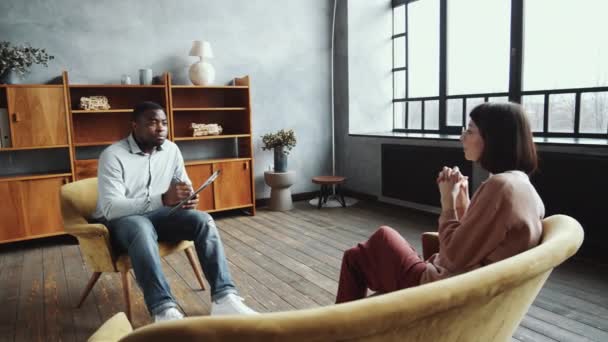 Bogenaufnahme Eines Afroamerikanischen Psychologen Der Einem Sessel Mit Klemmbrett Sitzt — Stockvideo