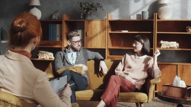 動揺白人男性彼の妻とソファに座って 泣いて カップルカウンセリングセッション中に女性心理学者への関係の問題について不満 — ストック動画